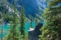 Alpine lake viewed through evergreen trees. - PhotoDune Item for Sale