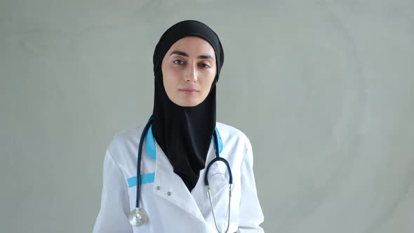 A Portrait of a Nurse Woman in a Black Hijab Medical Overalls and with a Stethoscope Around Her Neck