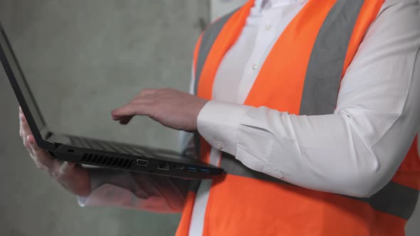 Foreman at a construction site with a laptop. Builder at a modern construction site.