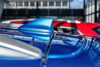  on the roof of a vehicle.  Blurry defocused background, fin, automobile, modern, technology, vehicle, equipment, car, transport, antenna, navigation, metal, auto, radio, gps, system, closeup, shark, aerial, rear, design, roof, metallic, concept, shape, mobile, outdoor, reflection, exterior, broadcast, reflecting, automotive, shine, signal, road, tuning, racing, part, waves, plastic, transportation, frequency, accessory, luxury, receiver, detail, view