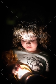 her face against the dark night background camping fun outdoors lamp light cute toy child face portrait curly hair holding hands, face, dark, night, torch, light, camp, interesting, girl, portrait, home, flashlight, kid, person, lifestyle, child, under, lamp, childhood, hand, search, cute, boy, little, flash, background, bed, story, hobby, adorable, bedtime, evening, blanket, growth, clothes, people