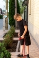 Eleven-year-old blond boy watering junipers with water - PhotoDune Item for Sale