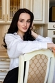 A young Caucasian girl with dark hair and big brown eyes is sitting in the kitchen - PhotoDune Item for Sale