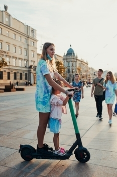  electric scooter in the city center. Concept of happy family. Candid people, real moments, authentic situation