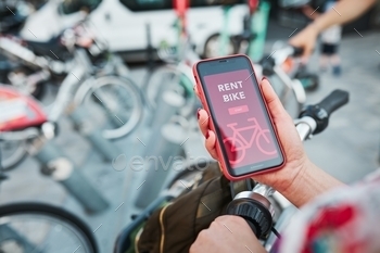 using rental app on smartphone. Using bike sharing city service. Paid rent of electric scooter. Using mobile phone to rent and pay for public eco transport. Bike sharing city station. Ecological transport alternative. 24/7 rental mobile service