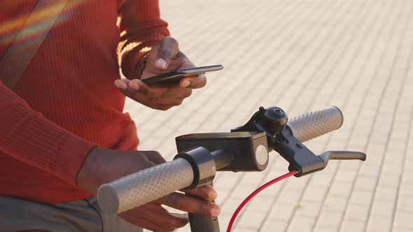 Man Activating Electric Scooter with Smartphone