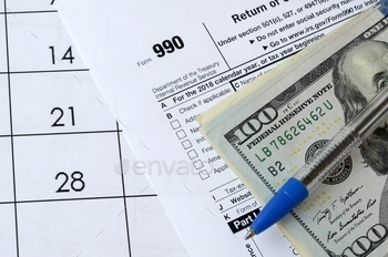  tax and blue pen with dollar bills lies on office calendar. Internal revenue service tax form blank
