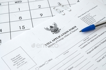 Thailand Visa application form and blue pen on paper calendar page close up