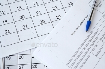 Typical Visa application form and blue pen on paper calendar page close up