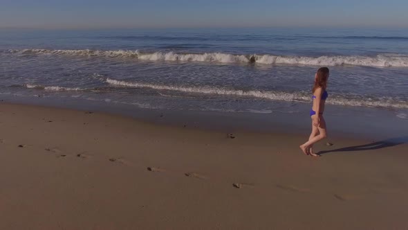 Woman Walking On The Beach