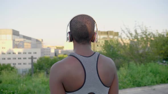 Young athletic woman with headphones walking to viewpoint