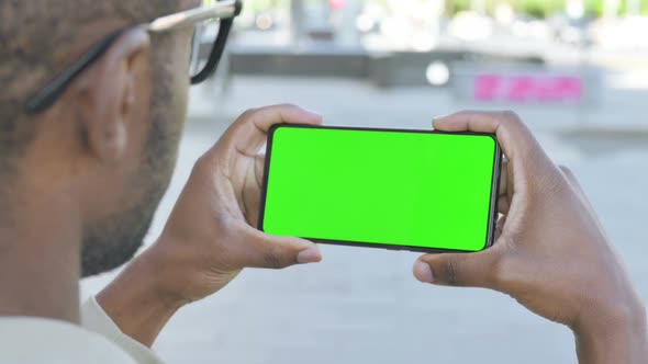 Close Up of African Man Watching Green Screen Smartphone Outdoor