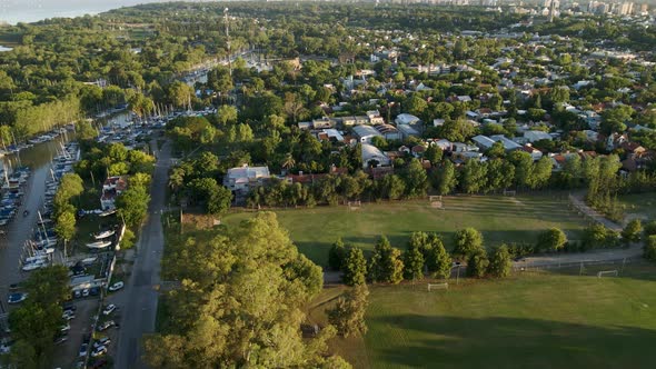 Aerial rising view of boats docked and soccer field in San Isidro, Buenos Aires. Dolly out