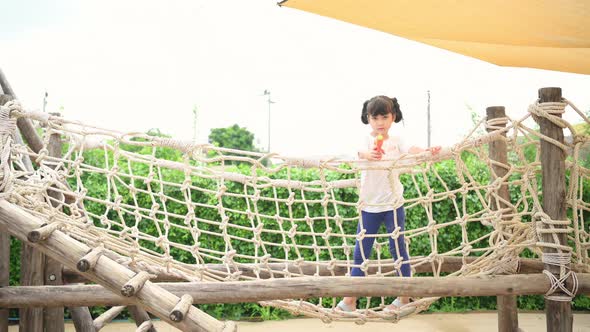 Children play with water in the village playground. with parents watching from a distance