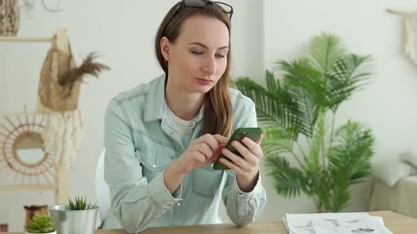 Brunette Woman Using Smartphone While Sitting in Office