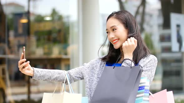 A woman taking a selfie in front of a shopping mall