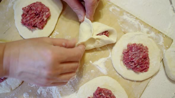 Female Hands Form Pies From Raw Dough and Meat Filling