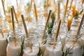 Milk in reusable glass bottles with golden drinking straws at the wedding party. - PhotoDune Item for Sale