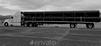 ing a trailer full of long, black PVC pipe for construction needs.