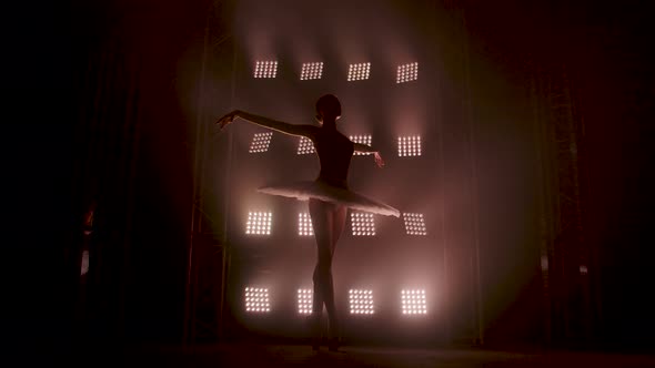 Graceful Silhouette Ballerina Dancing in Black Dress in the Studio in Spotlight on the Stage of the