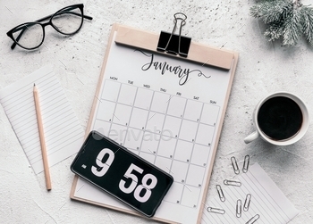 endar on table. Mobile phone with flip clock on screen over calendar on bright background.
