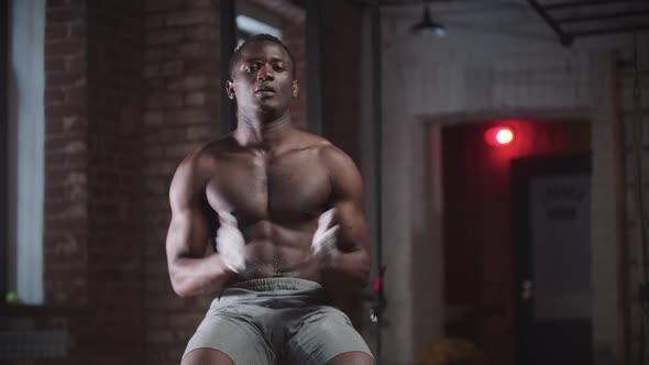 A Black Handsome Man Training in the Gym Covering Hands in Chalk and Clapping Looking in the Camera