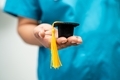 Doctor holding graduation gap hat in nursing hospital. - PhotoDune Item for Sale