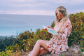 Woman with long hair reading a book outdoors  - PhotoDune Item for Sale