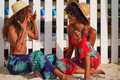 Two black women friends at the beach laughing having conversation - PhotoDune Item for Sale