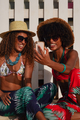 Two black women at the beach Talking on the video chat with mobile phone - PhotoDune Item for Sale