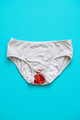 Women period panties with the glitter as a representation of menstruation on the blue background - PhotoDune Item for Sale