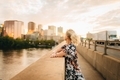 Woman on bridge looking at Hartford, Connecticut cityscape at sunset - PhotoDune Item for Sale