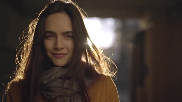 Portrait of Young Longhaired Woman Being Sunlit Posing on Camera with Beautiful Smile in Slow Motion