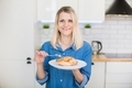 A girl in a blue denim shirt is holding a plate with ready-made chicken breast white meat. - PhotoDune Item for Sale
