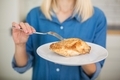 A girl in a blue denim shirt is holding a plate with ready-made chicken breast white meat. - PhotoDune Item for Sale