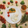Fried eggs are on a white plate. Broccoli and cherry tomatoes lie around. Healthy food concept.  - PhotoDune Item for Sale