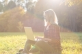 Gen Z. Girl sitting with laptop in the park. A young woman in the park with a laptop. Freelance work - PhotoDune Item for Sale