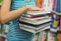 girl holding a stack of books or textbooks. Back to school. Book Shop. - PhotoDune Item for Sale