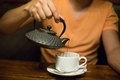 A man pours tea into a cup from an earthen teapot. Tea drinking. - PhotoDune Item for Sale