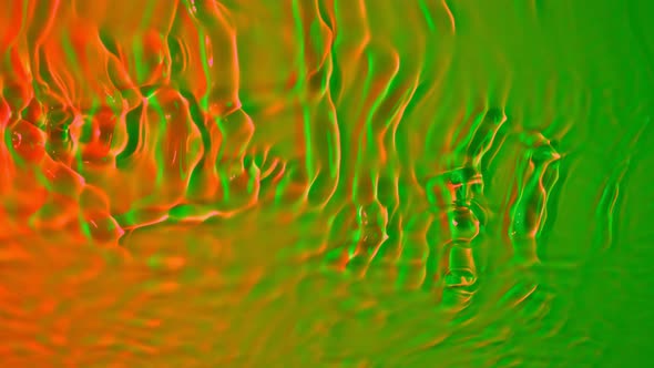 Super Slow Motion Abstract Shot of Swirling Green and Orange Neon Water at 1000Fps