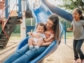 Young mother at the park having fun with her children on a blue slide  - PhotoDune Item for Sale