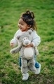 Diverse toddler girl at playground park running with her favorite stuffed teddy bear  - PhotoDune Item for Sale