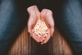Woman holding a hand full of pills while sitting on the floor  - PhotoDune Item for Sale