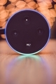 Amazon Alexa echo dot on wooden table with blurred lights in background  - PhotoDune Item for Sale