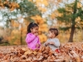 Mixed race siblings at the park playing in beautiful fall leaves, both having fun - PhotoDune Item for Sale