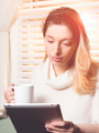 woman looking at tablet with mug in hand, back light by the sun - PhotoDune Item for Sale