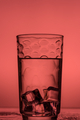 water in glass with ice cubes on red background - PhotoDune Item for Sale