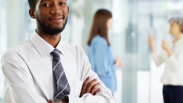 Businessman standing with arms crossed in office