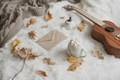 Hot drink with marshmallows, ukulele, autumn leaves in neutral colors - holidays season - PhotoDune Item for Sale