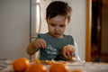 A little boy cleans tangerines at home in the kitchen. New Year's mood - PhotoDune Item for Sale